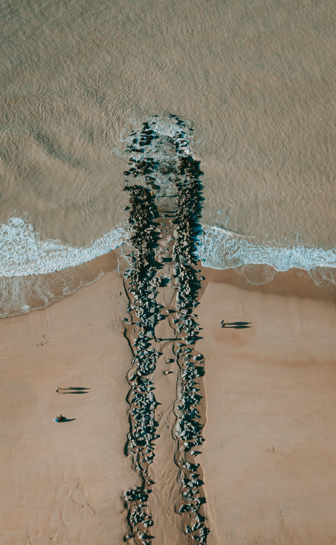 a group of people standing on top of a sandy beach