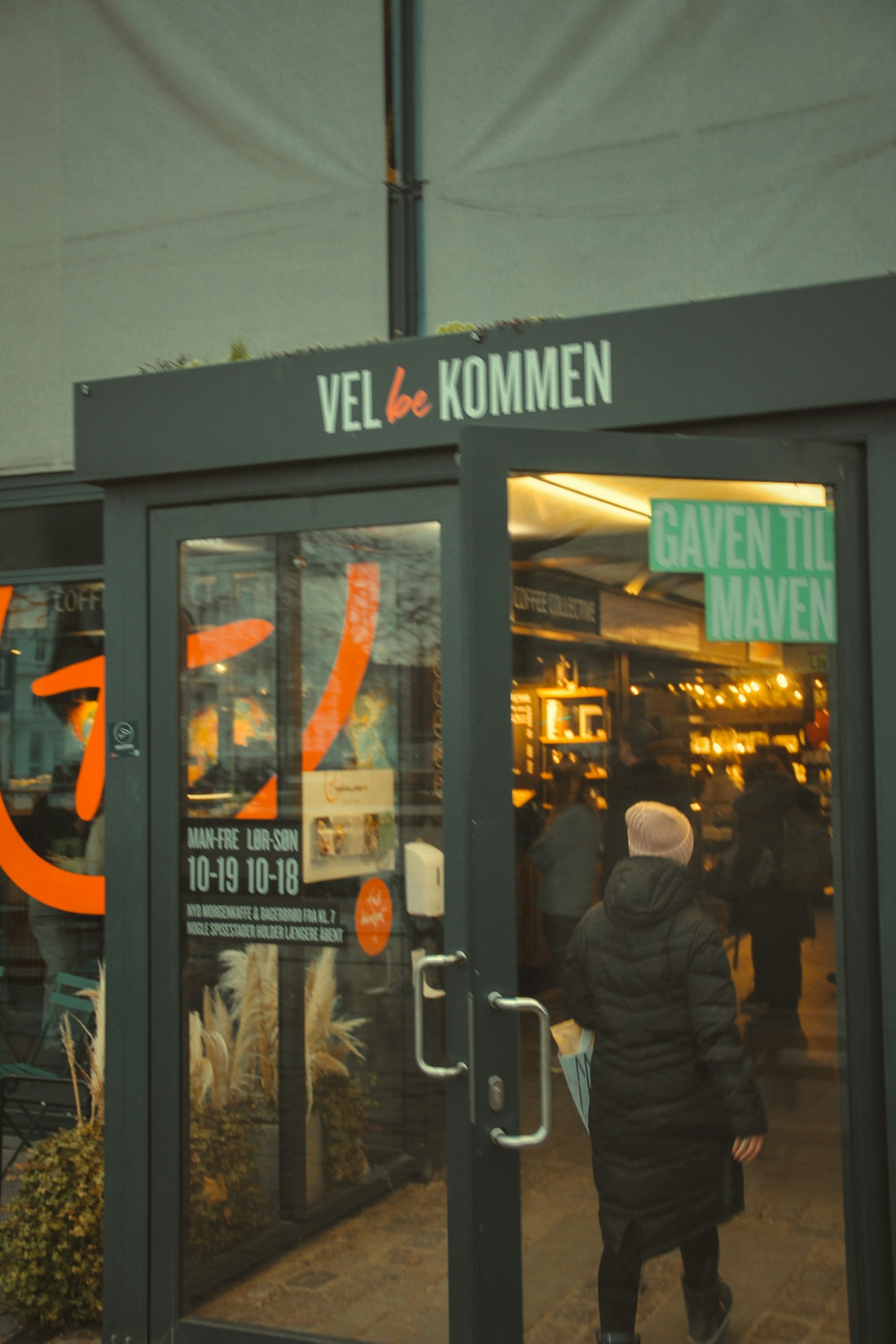 a person walking out of a building with a sign on it