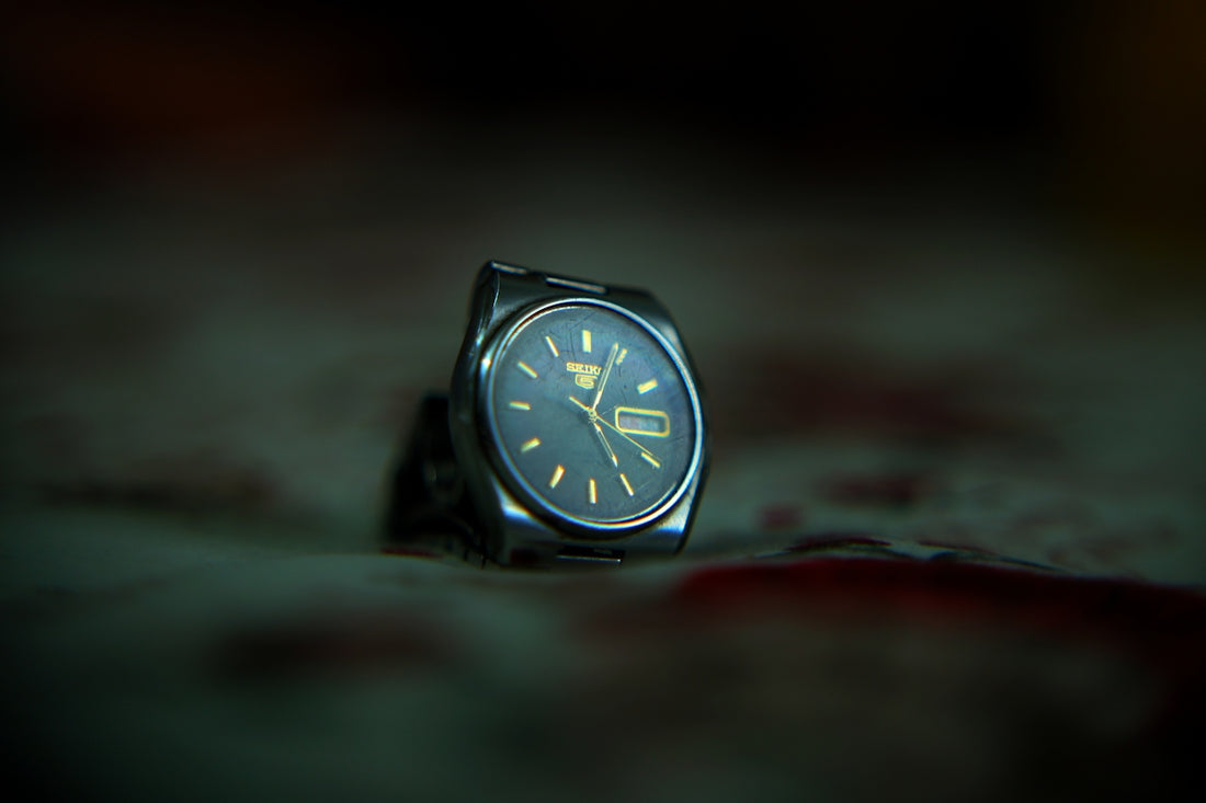 A watch sitting on the ground in the dark
