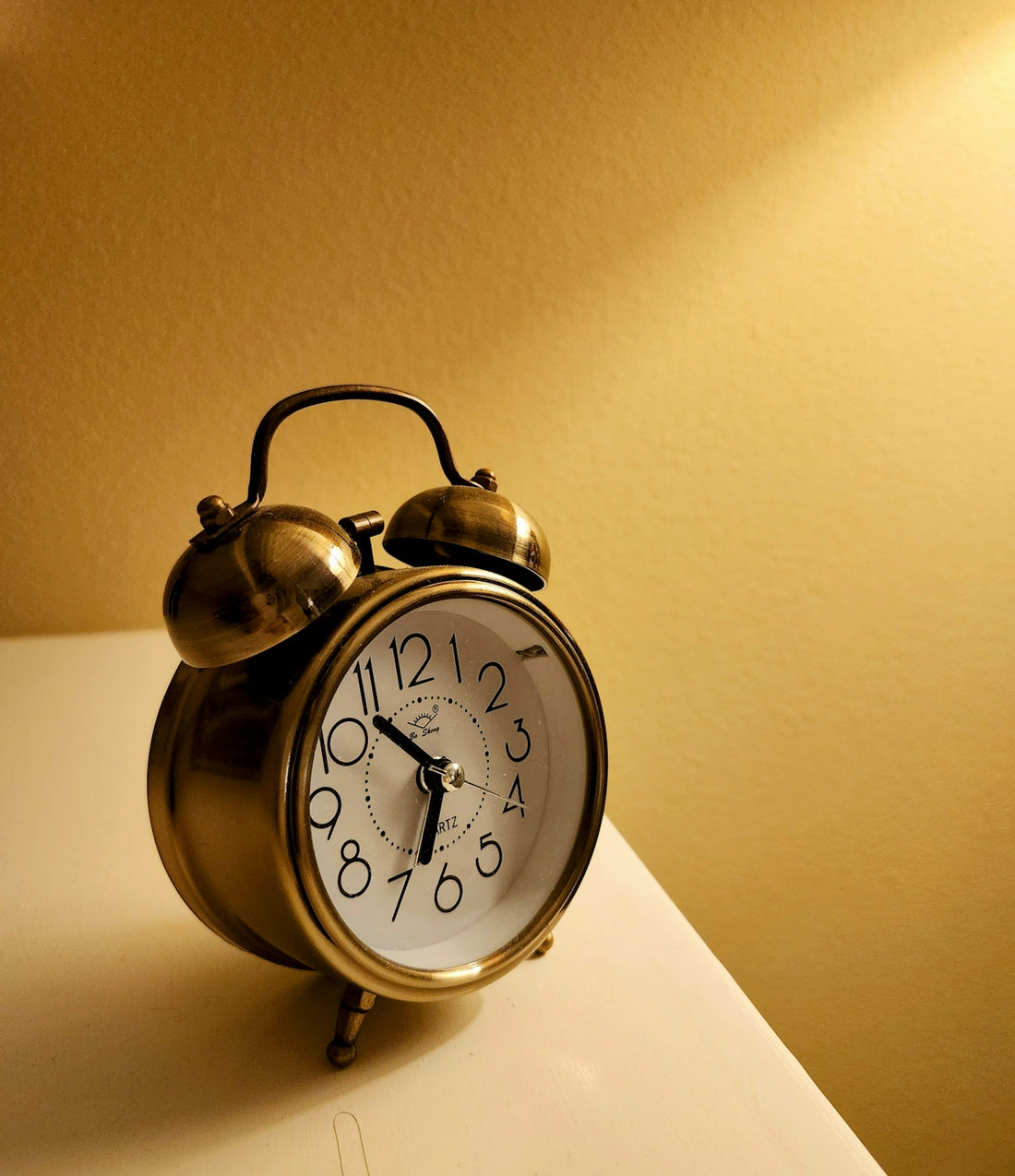 An alarm clock sitting on top of a white table