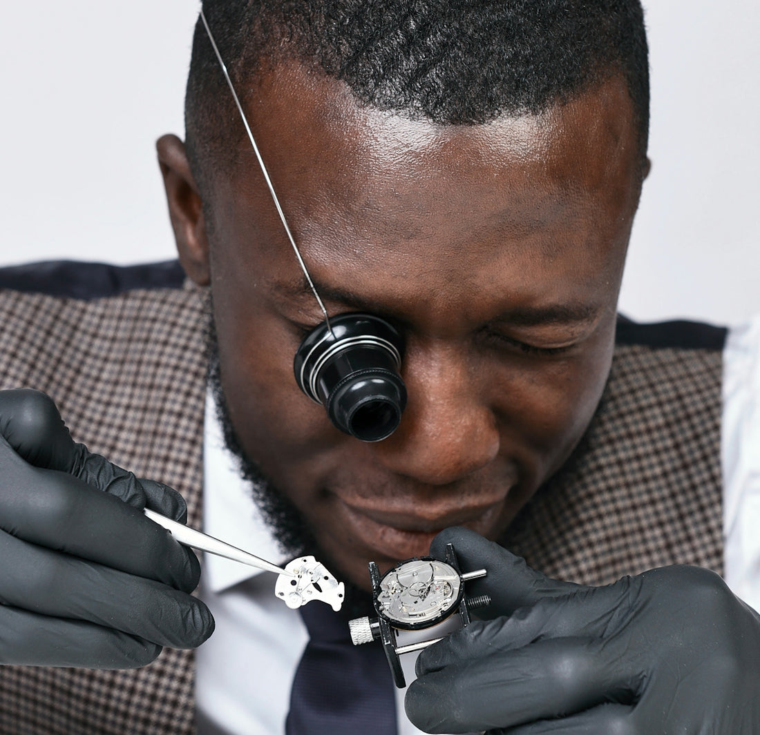A man in a suit and tie is fixing a watch