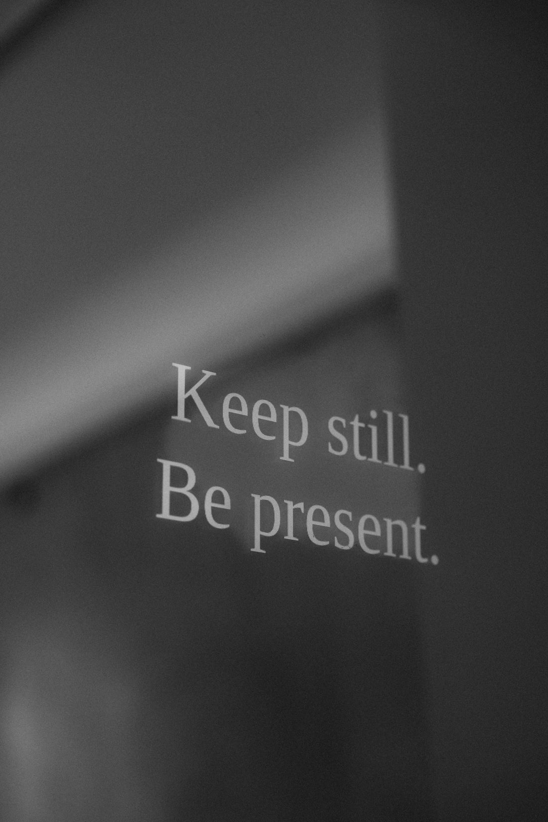 A black and white photo of a sign on a wall