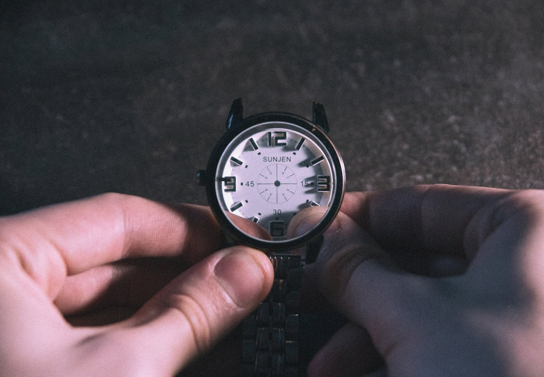 A person holding a watch in their hand