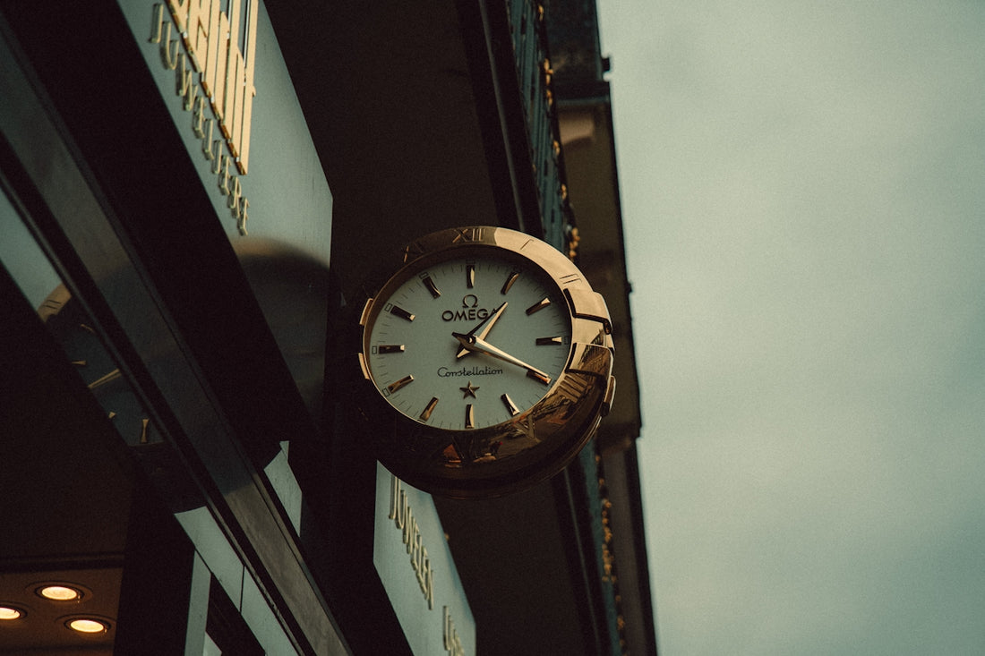 An ornate clock hangs on a building's exterior.