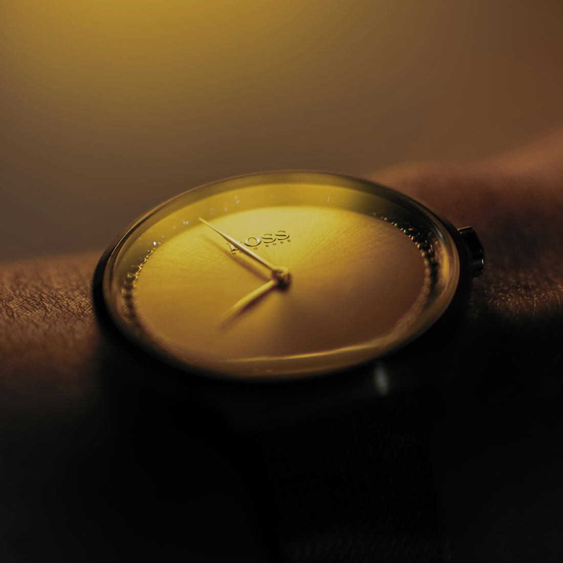 Close-up of a golden minimalist watch on a wrist.