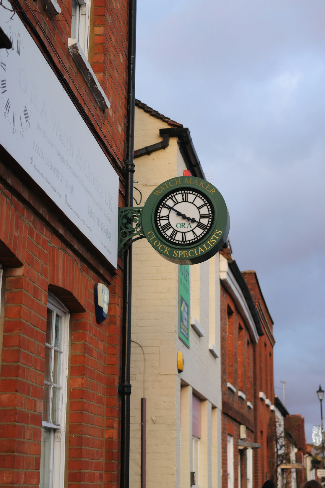 A round clock sign on a brick building